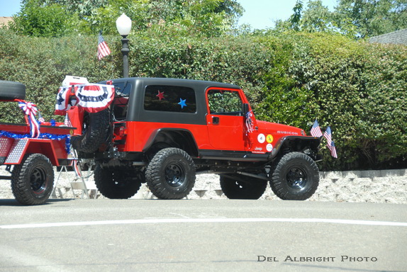 Jeep with trailer decorated with flags in parade